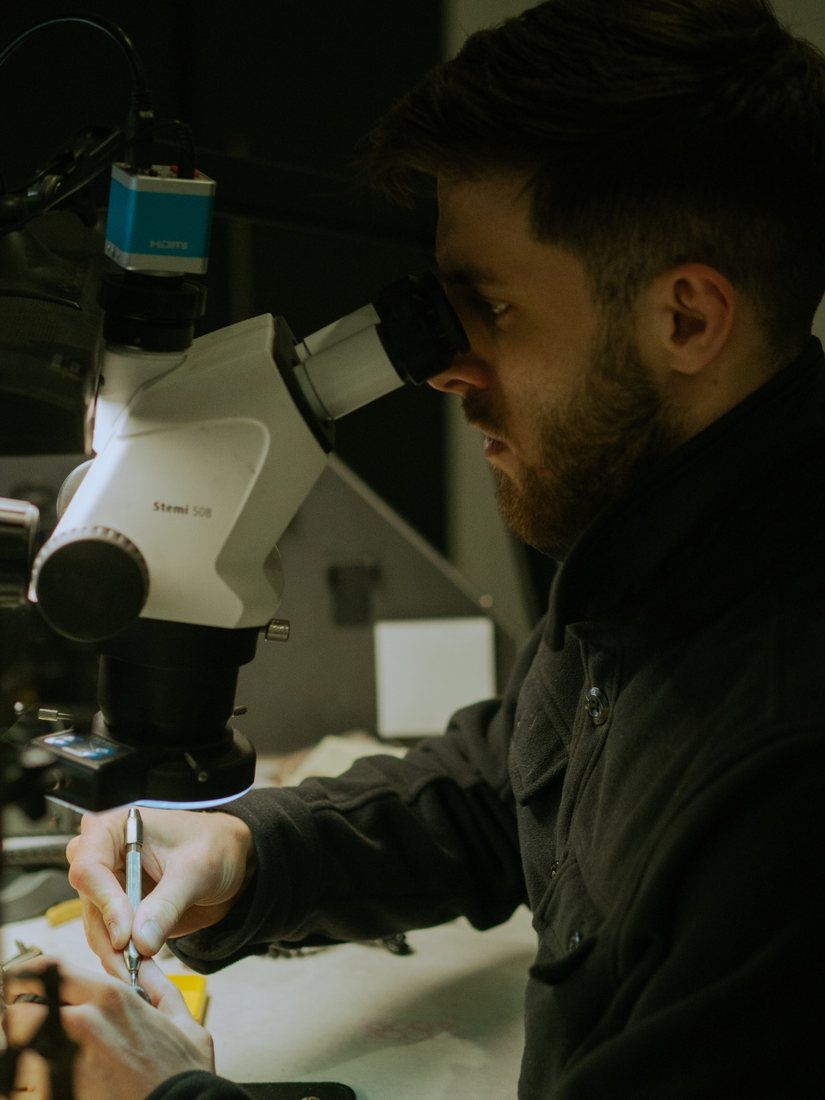 Olly at the bench in his Birmingham Jewellery Quarter workshop, working under the microscope
