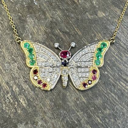 Butterfly pendant necklace set with rubies, emeralds and a sapphire