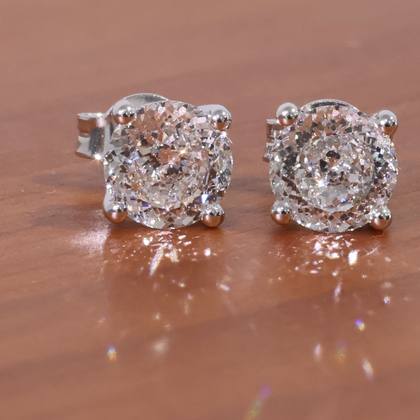 A pair of diamond stud earrings, four claw set in white gold